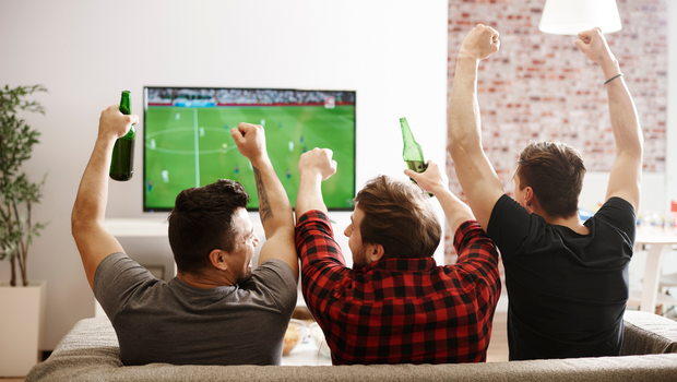 three males watching football playing drinking games