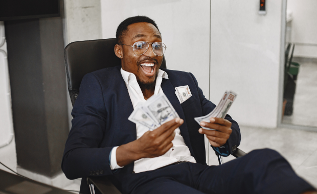 Man in business suit holding money – representing the cost of a stag do, balancing budget with a legendary experience.