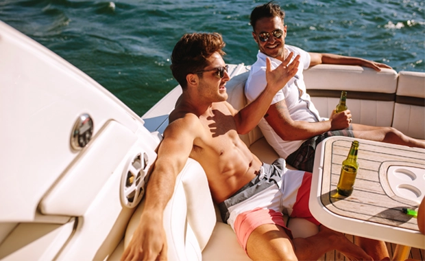 couple of guys on a stag do relaxing on a catamaran in the sun